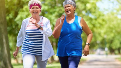 Two older women in workout clothes walking