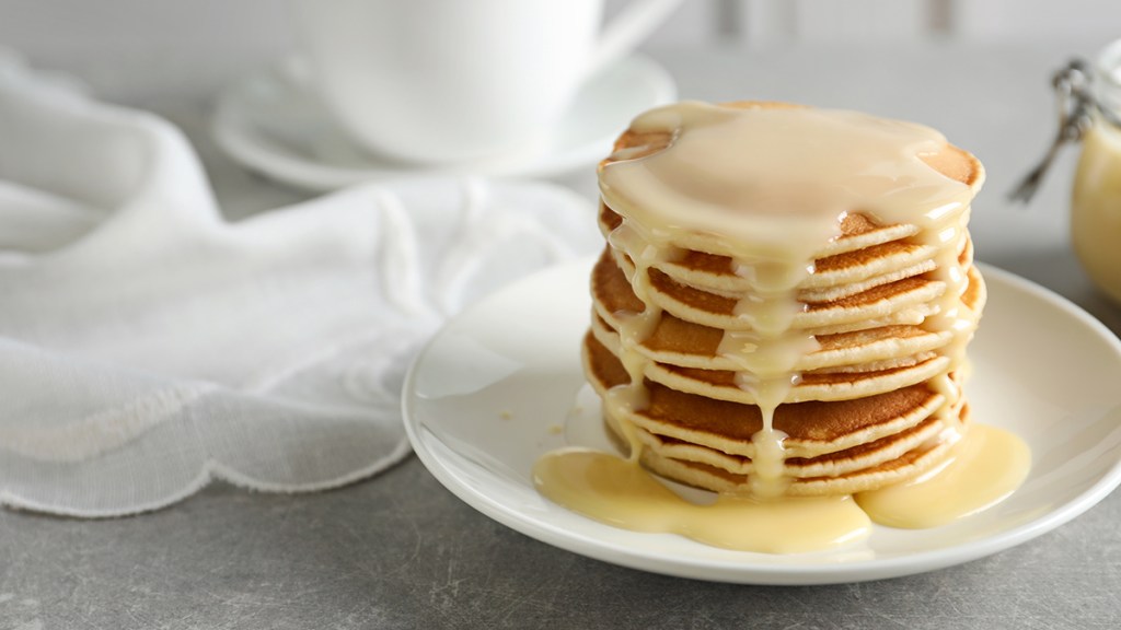 Sweetened condensed milk drizzled over pancakes