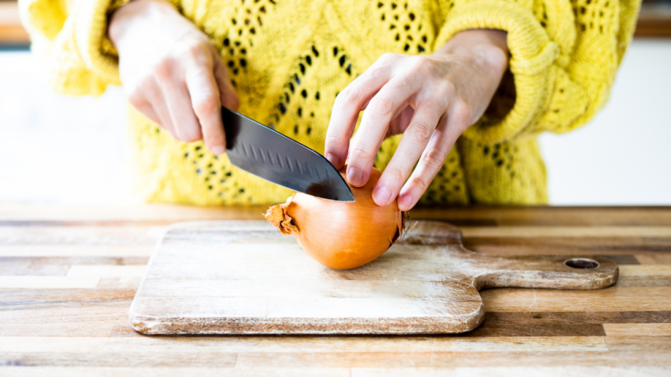 Woman's hands cutting onion