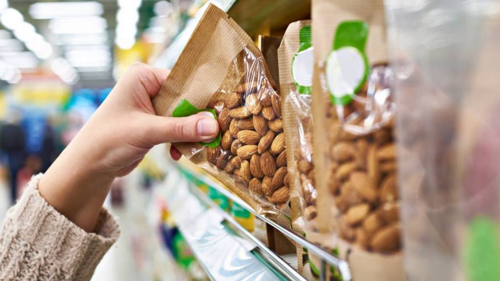 Hand choosing almonds in a store