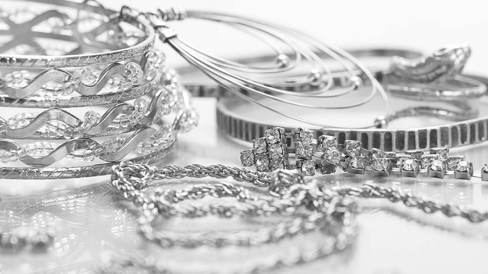 Different pieces of silver jewelry on a table