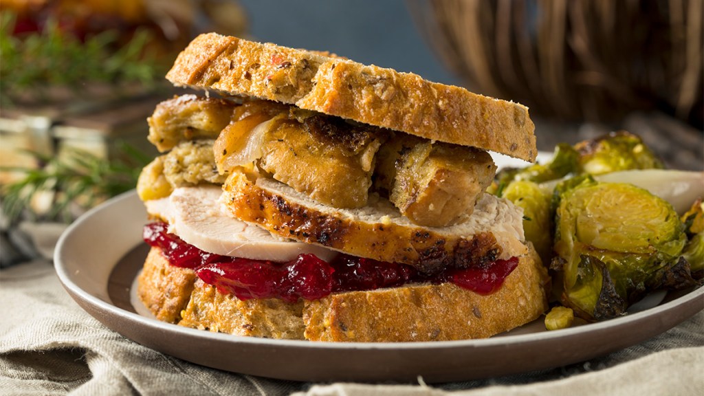 A Leftover turkey sandwich shown as part of a guide on reheating it