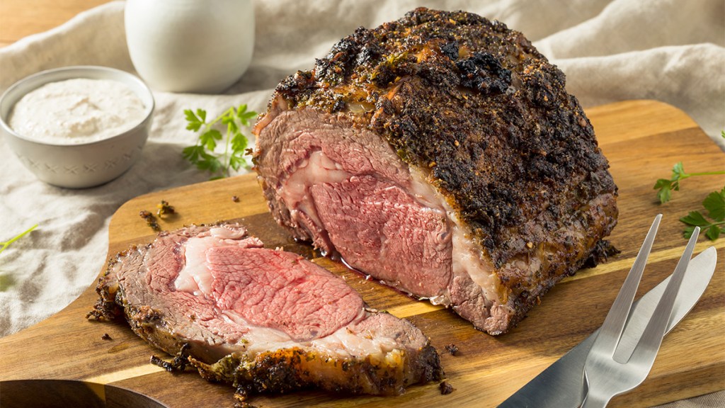 Roasted prime rib on a cutting board as part of a guide on how to reheat it