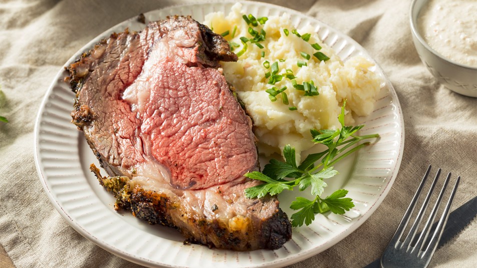 Slice of prime rib with mashed potatoes as part of a guide on how to reheat it