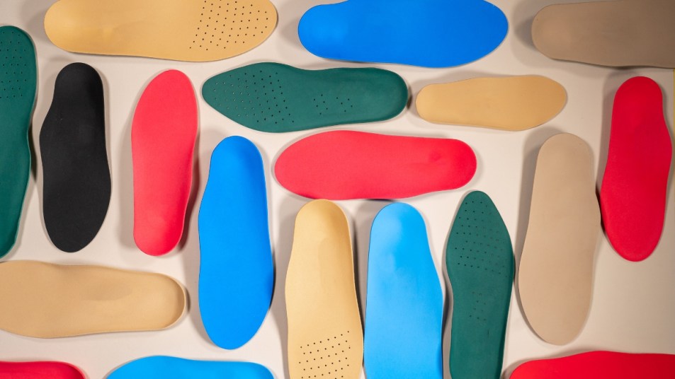 pairs of colorful orthotics laid out on a table, birds-eye view