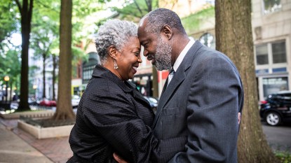 Senior couple, black woman and black man, embracing in downtown area