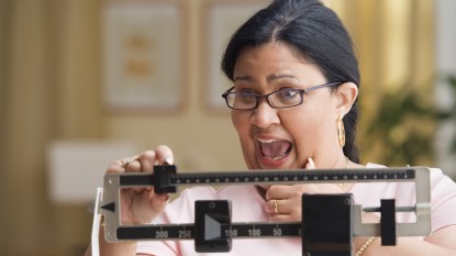 Shocked woman weighing herself
