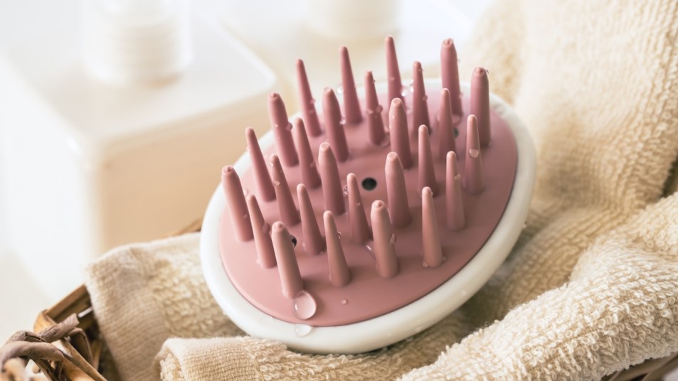 pink scalp brush on a white towel