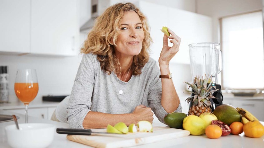 Woman happily eating fruit