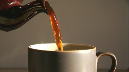 pouring tea into a mug close up