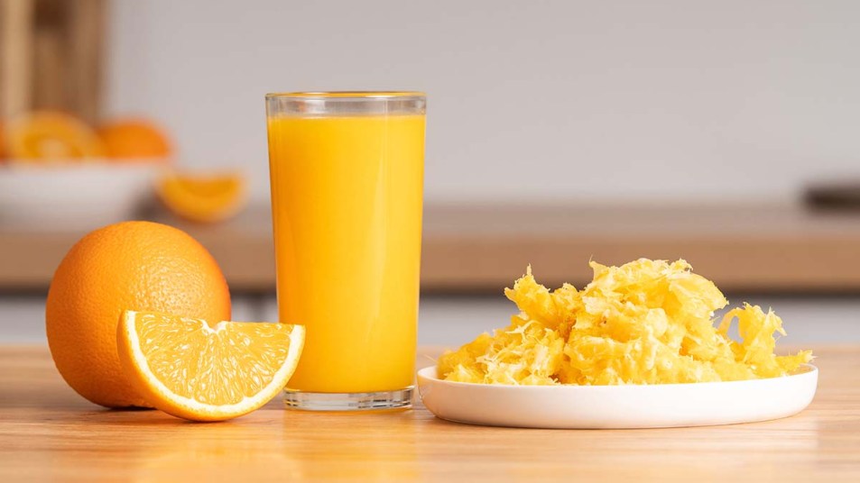 A glass of orange juice and pulp
