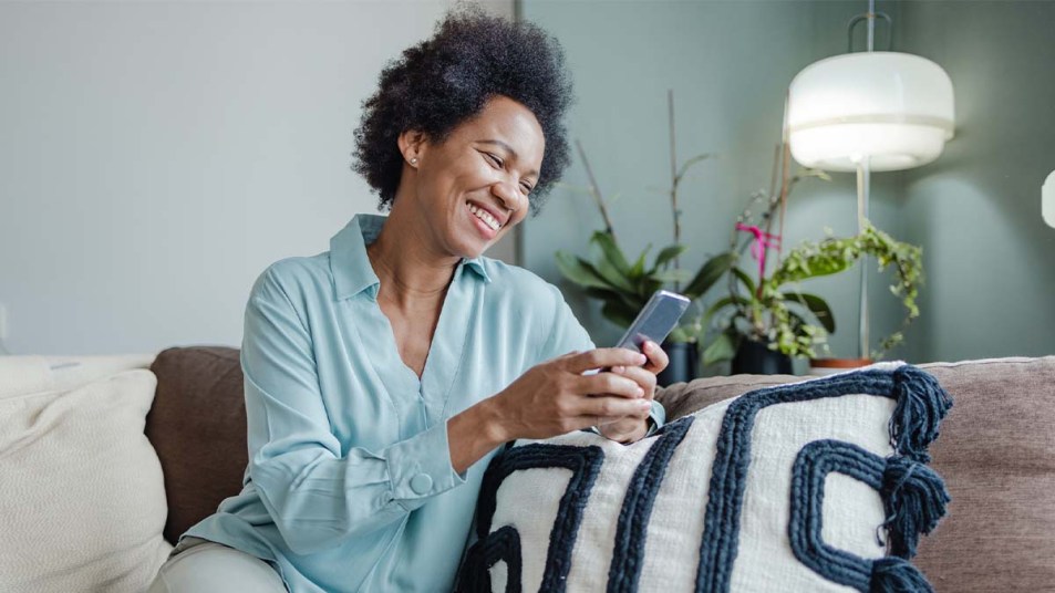 A woman looking and smiling at her phone