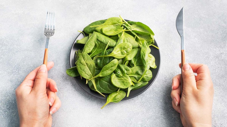 Woman about to eat a plate of baby spinach
