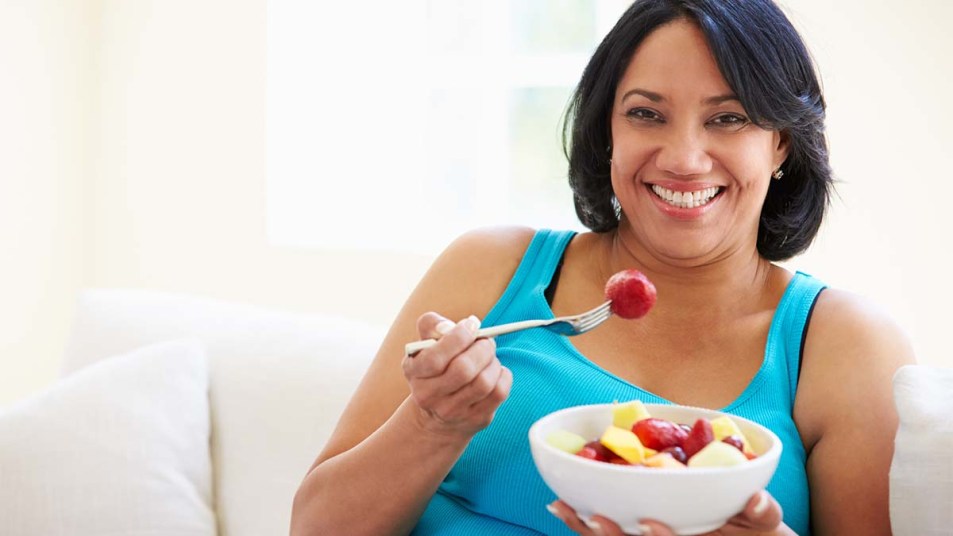 Woman eating a bowl of fruit
