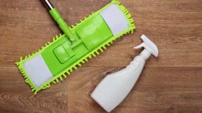 flat mop and spray bottle on floor, how to clean your walls concept