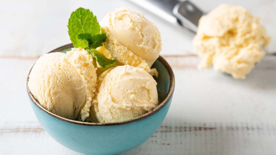 Vanilla-ice-cream-in-a-blue-bowl-garnished-with-a-sprig-of-mint