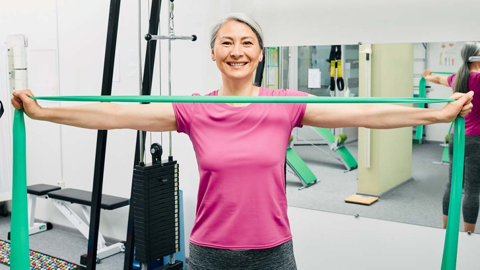 Woman holding a resistance band in a home gym