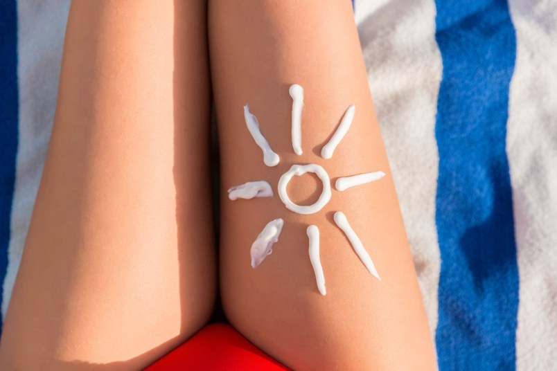 Sunscreen in shape of a sun on a woman's legs