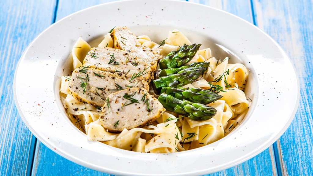 Chicken, asparagus and carrots with egg noodles as part of a guide on how to store scallions