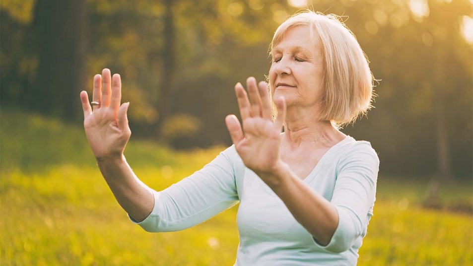 Senior-woman-enjoys-exercise-Qi-Gong-or-Tai-Chi-in-the-nature