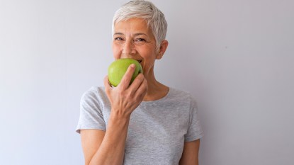 woman eating an apple: best foods to eat for gut health