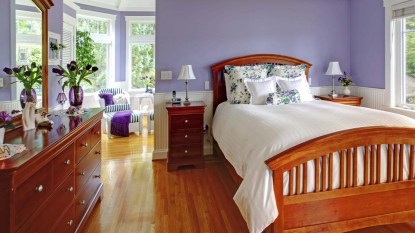 Bedroom interior with purple walls, brown furniture and hardwood floor.jpg