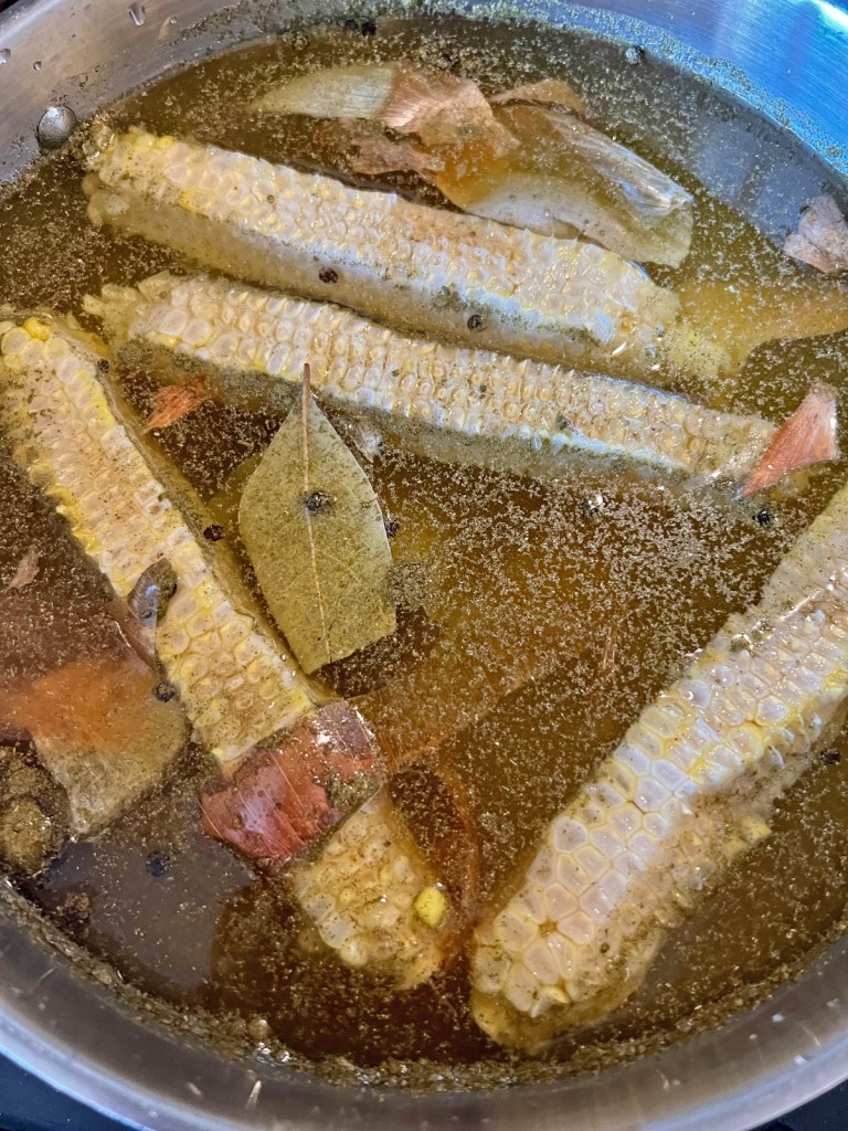 food scraps like onion skins and corn cobs in a stock pot with water