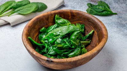 Lightly steamed spinach in a wooden bowl
