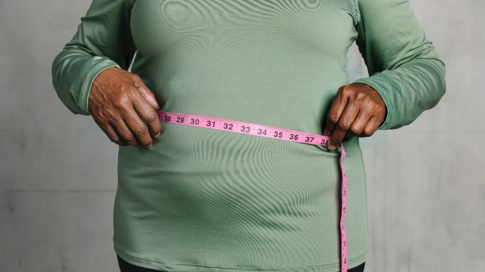 mature woman measuring her stomach, concept for diabetes and weight loss