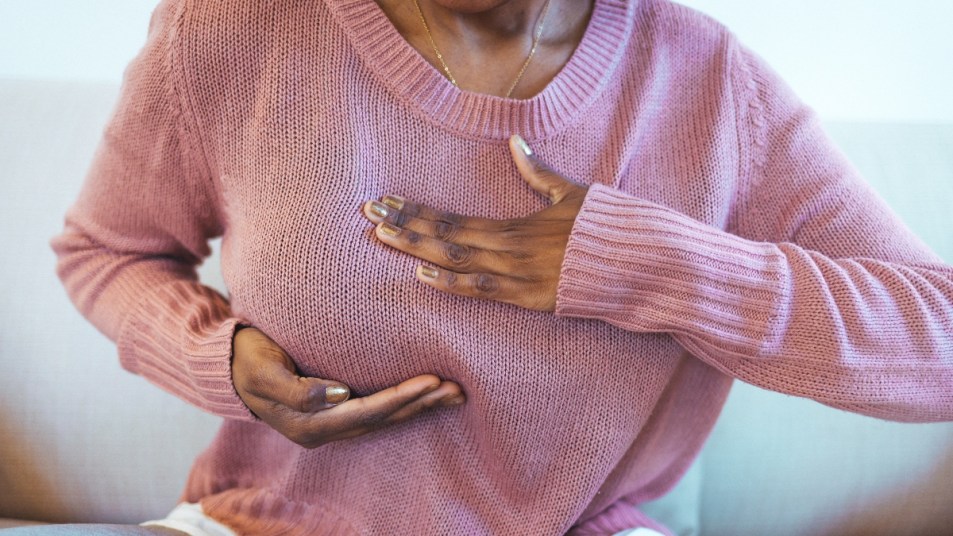 mature woman touching her breast in pain, concept for breast discharge