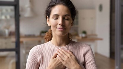 Woman sitting in her living room and praying or meditating