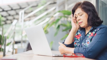 mature woman tired in the afternoon at her laptop