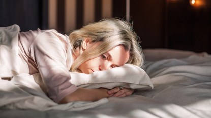 mature woman with menopause period symptoms lying in bed