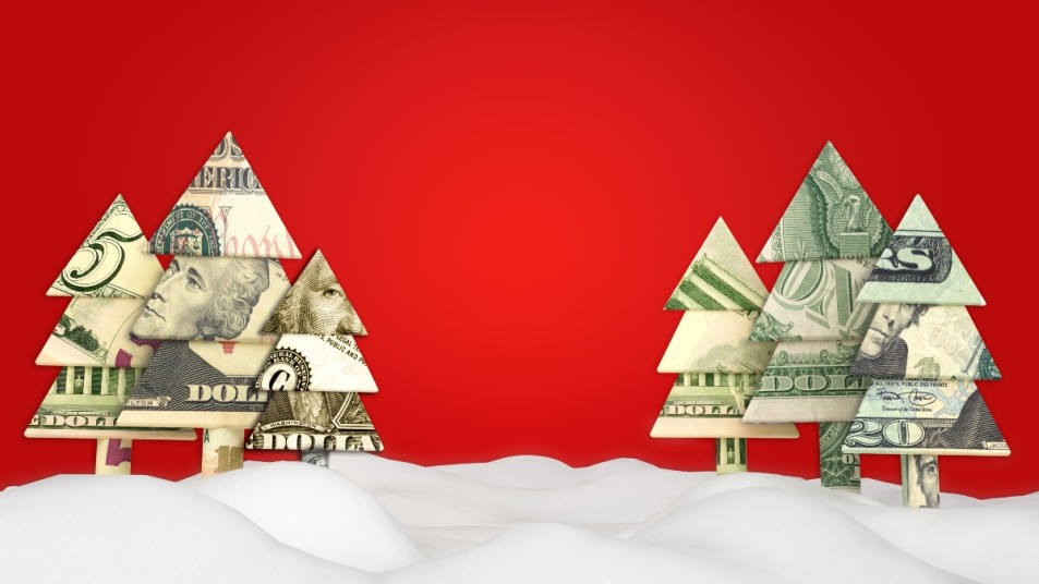 Holiday Christmas savings or sale advertisement. Origami money Christmas tree's in the snow with a red background with room for text or copy space.
