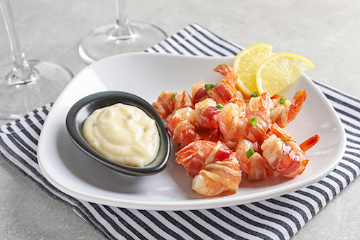 Plate of bacon-wrapped shrimp with lemon and aioli