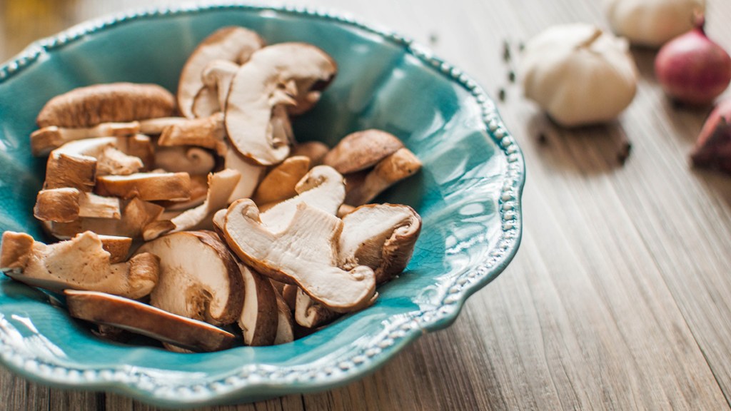 Sliced mushrooms in a teal bowl left out in the sunlight so their vitamin D levels will increase