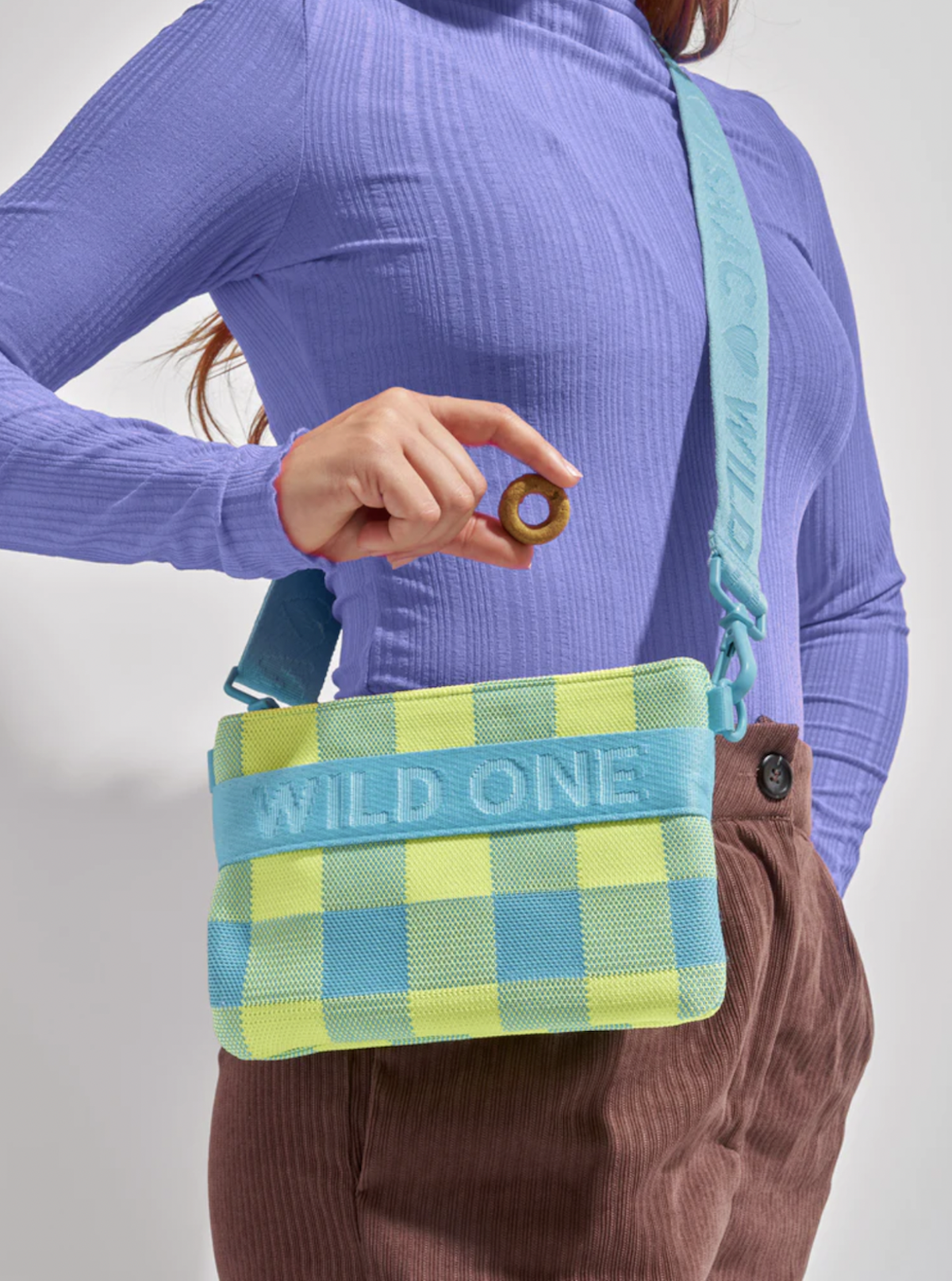 Woman wearing Wild One dog treat pouch and holding treat