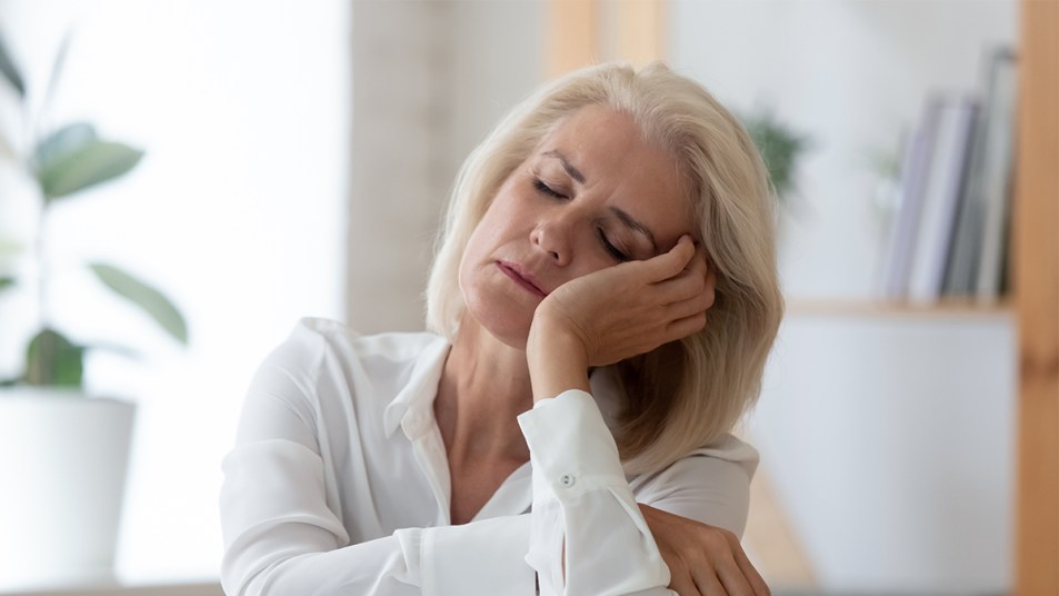 woman asleep at a desk: does vitamin d deficiency cause fatigue?