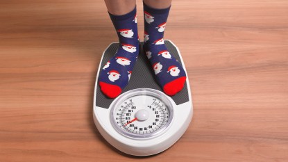 woman in santa claus socks standing on scale
