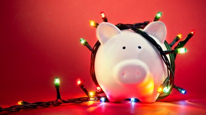 piggy bank wrapped in holiday christmas lights, concept to save on holiday gifts