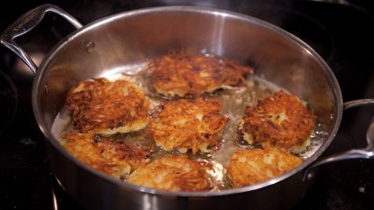 Latkes frying in oil in pan