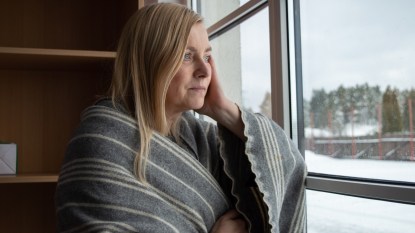 Woman contemplating at window in winter