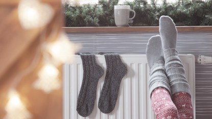 Woman in socks with feet on heater