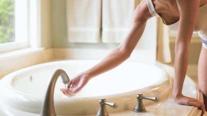 woman filling up bath tub for bleach bath for eczema