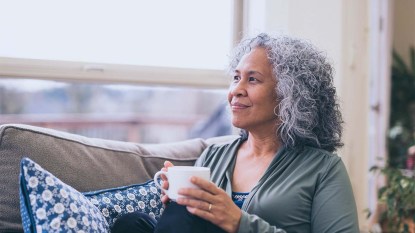 Woman with a mug of coffee in her home