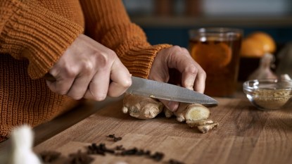 Woman's hands cutting ginger