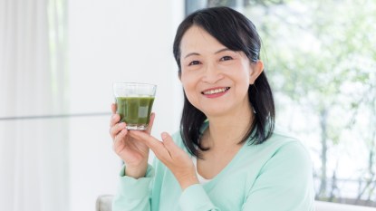 Middle aged woman with green smoothie.