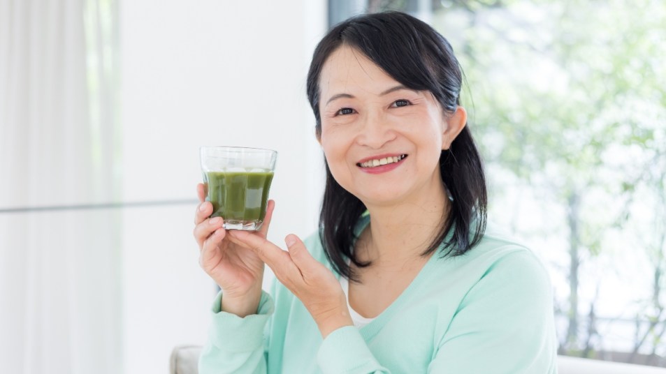 Middle aged woman with green smoothie.