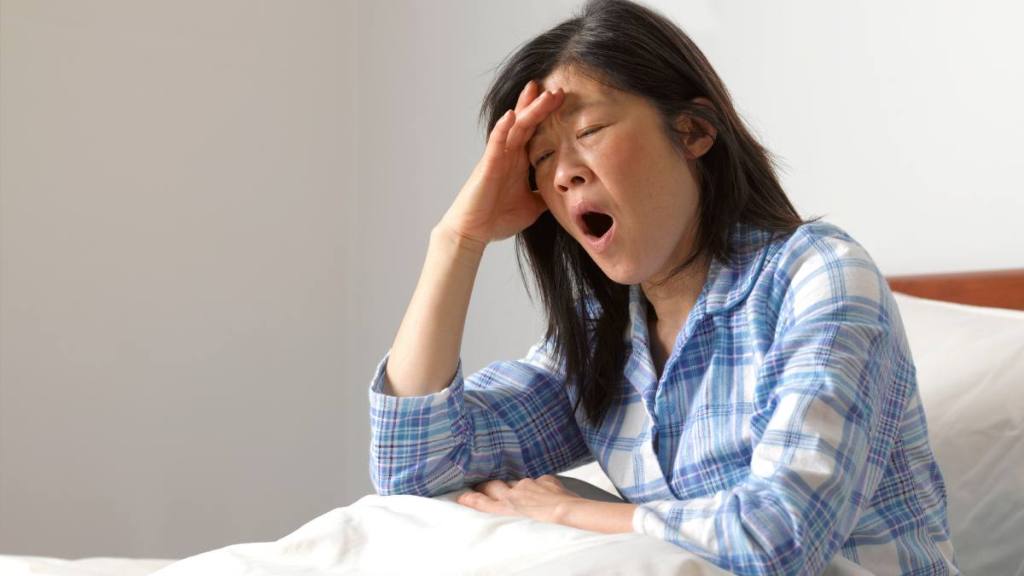 Woman yawning in bed ;  how to improve indoor air quality
