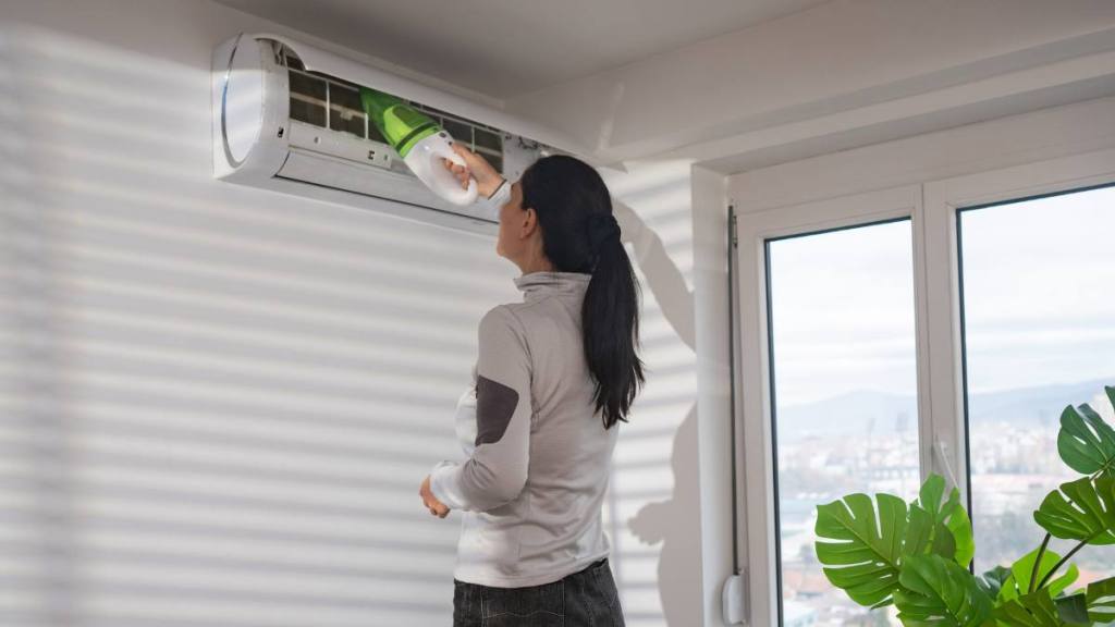 Woman cleaning air conditioner